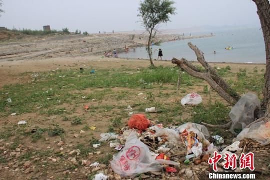 图为岗南水库大坝内游泳的人群和被丢弃的垃圾。 王天译 摄 图为岗南水库大坝内游泳的人群和被丢弃的垃圾。 王天译 摄