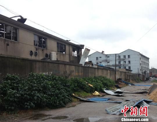 工厂发生火灾后,大火将彩钢瓦掀到围墙外 孙权 摄 工厂发生火灾后,大火将彩钢瓦掀到围墙外 孙权 摄