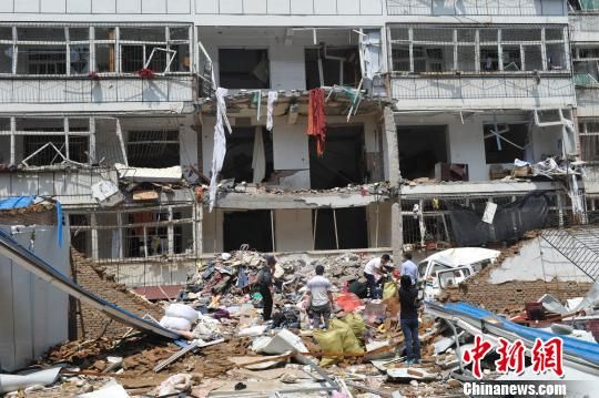 在发生爆炸居民楼南侧,多位市民正在清理财物。 韦亮 摄 在发生爆炸居民楼南侧,多位市民正在清理财物。 韦亮 摄