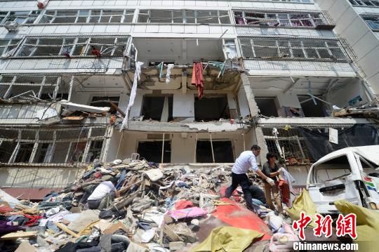 在发生爆炸居民楼南侧,多位市民徒手清理财物。 韦亮 摄 在发生爆炸居民楼南侧,多位市民徒手清理财物。 韦亮 摄