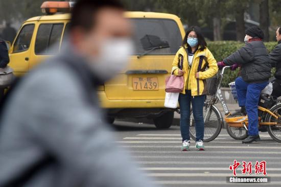 北京街头市民佩戴口罩出行。 中新网记者 金硕 摄 北京街头市民佩戴口罩出行。 中新网记者 金硕 摄